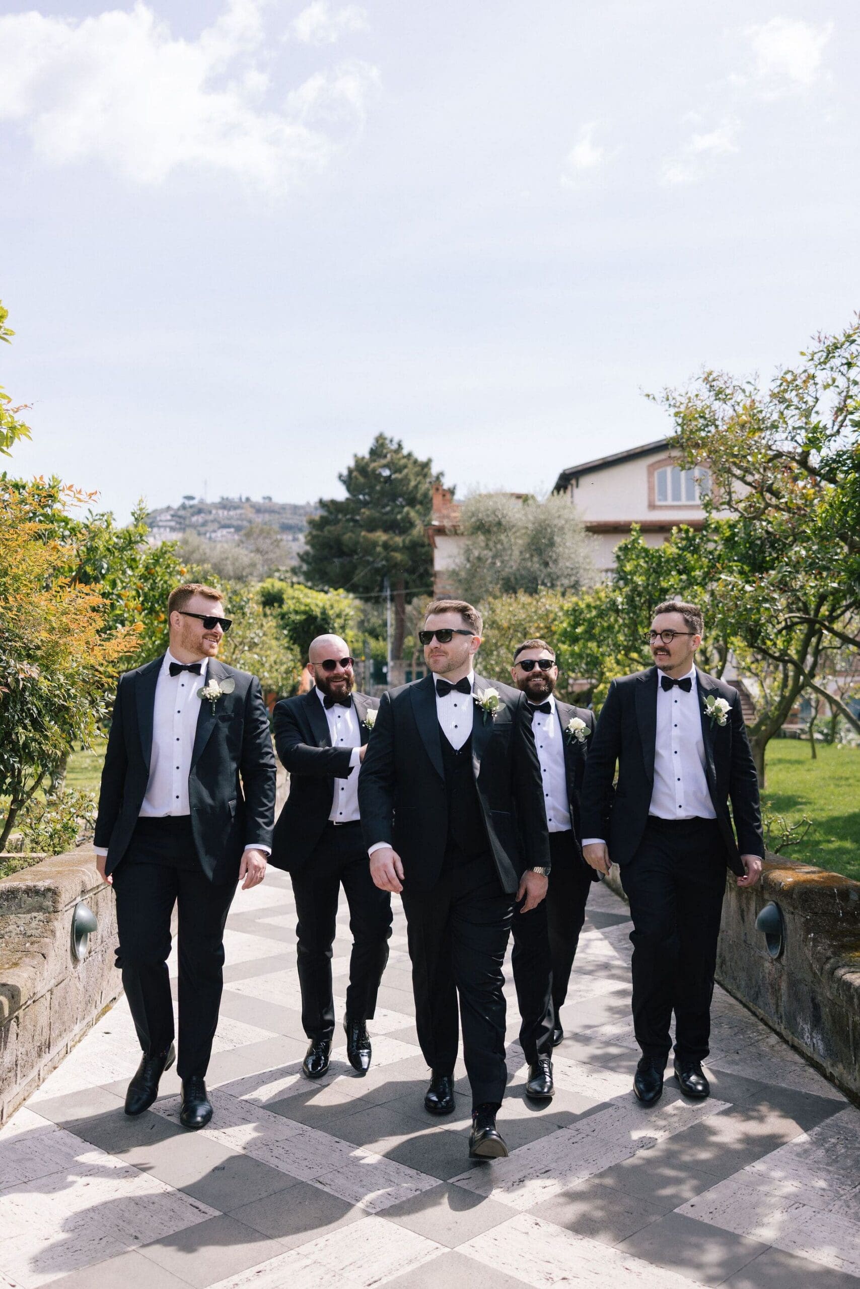 The groom and groomsmen walking up to Villa Antiche Mura
